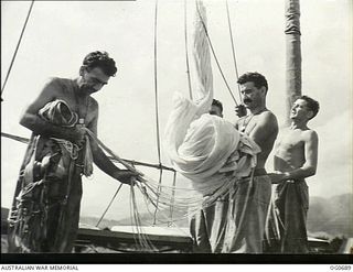 NADZAB, NEW GUINEA. C. 1944-02. GATHERING A PARACHUTE AFTER ITS PERIODICAL AIRING AT NO. 24 (VULTEE VENGEANCE) SQUADRON RAAF ARE: LEADING AIRCRAFTMAN C. A. PITTAWAY, BALACLAVA, SA; CORPORAL L. ..