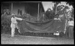 Malakai Veisamasama and European man holding very old piece of tapa cloth