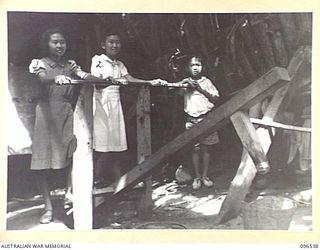 RABAUL AREA, NEW BRITAIN. 1945-09-13. CHINESE CIVILIANS, INTERNED BY THE JAPANESE AT A CAMP 15 MILES WEST OF RABAUL, WERE CONTACTED BY A PARTY OF AUSTRALIAN ARMY AND RED CROSS OFFICIALS SOON AFTER ..