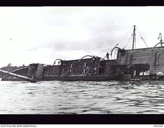 MILNE BAY, NEW GUINEA. 1943-06-29. CHINESE FREIGHTER "ASHUN" LYING ON HER SIDE AFTER BEING SUNK BY JAPANESE WARSHIPS DURING THE BATTLE FOR MILNE BAY