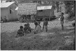 Children playing in grass clearing next to houses