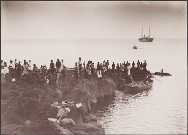 Locals on the landing rock of Merelava and the Southern Cross in background, Banks Islands, 1906 / J.W. Beattie