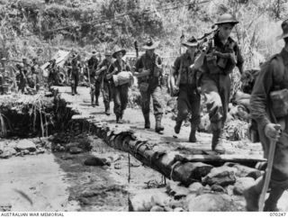 FARIA VALLEY, NEW GUINEA. 1944-02-10. MEMBERS OF A COMPANY, 2/10TH INFANTRY BATTALION CROSSING THE FARIA RIVER AT BEVERIDGE'S POST, NEAR GUY'S POST