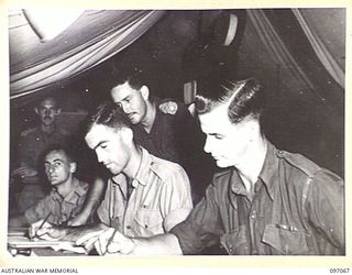 PERSONNEL AT WORK IN THE CIPHER OFFICE, 11 DIVISION SIGNALS. IDENTIFIED PERSONNEL ARE:- SERGEANT R. J. MORRIS (1); CORPORAL E. H. HIGGONSON (2); CAPTAIN G. J. S. GILCHRIST (3); SERGEANT I. H. ..