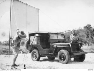 1943-05-05. NEW GUINEA. ERECTING A COLLAPSIBLE SCREEN FOR TALKIES SOMEWHERE IN NEW GUINEA. NOTHING IS APPRECIATED MORE BY TROOPS, ESPECIALLY IN BATTLE AREAS, THEN TALKIES, AND EVEN HEAVY RAIN WILL ..
