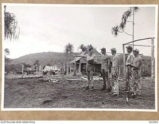 DREGER HARBOUR, NEW GUINEA. 1943-12-05. LIEUTENANT JOHN A. WALLER OF OAKLAHOMA, USA, OF THE 341ST UNITED STATES FIGHTER SQUADRON GIVING SOME OF THE SQUADRON TECHNICIANS ORDERS AS TO THE CAMP LAYOUT