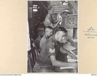 BORAM, NEW GUINEA. 1945-11-16. CLERKS STOCKTAKING IN THE MAIN STORE AT 3 BASE SUB AREA, AUSTRALIAN ARMY CANTEENS SERVICE. IDENTIFIED PERSONNEL ARE:- SERGEANT A.A. CLAIR (1); CORPORAL J.L. PARKER ..