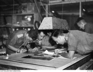 TOROKINA, BOUGAINVILLE ISLAND. 1944-12-30. PERSONNEL OF THE INTELLIGENCE TOPOGRAPHICAL SECTION PREPARING MAPS AND AERIAL PHOTOGRAPHS FOR USE IN THE BATTLE ROOM AT HEADQUARTERS, 2ND AUSTRALIAN ..