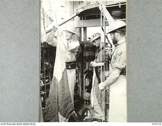 AT SEA. 1944-09/08. MEMBERS OF THE CREW OF THE RAN CORVETTE, GEELONG BENDING SIGNAL FLAGS ON THE HALYARD AS THE VESSEL PROCEEDS ON HER PATROL ALONG THE COAST OF NEW GUINEA