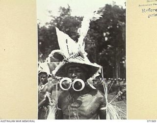 SONG RIVER, FINSCHHAFEN AREA, NEW GUINEA. 1944-03-26. A FINSCHHAFEN BOY IN CEREMONIAL DRESS AT THE SING-SING IN THE AUSTRALIAN NEW GUINEA ADMINISTRATIVE UNIT COMPOUND HELD TO CELEBRATE RE ..