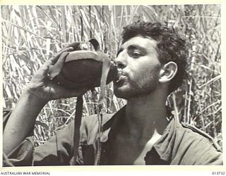 1942-12-05. NEW GUINEA. GONA. THESE AUSTRALIANS HAVE JUST COME 100 YARDS BACK FROM THE FRONT LINE FOR FOOD DURING A LULL IN THE FIGHTING. THEY ARE PART OF A COMPANY WHICH HAS BEEN 2 DAYS AND NIGHTS ..