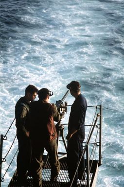 Helicopter crewmen from Marine Medium Helicopter Squadron 261 (HMM-261) prepare to fire an M-2 .50-caliber machine gun from the stern of the amphibious assault ship USS SAIPAN (LHA-2) during weapons training held prior Operation Sharp Edge. The SAIPAN is on station off the coast of Liberia