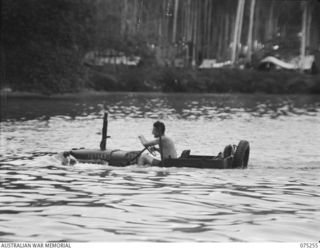 MILILAT, NEW GUINEA. 1944-08-13. VX137730 WARRANT OFFICER II, N.W. GRANGER (1) DRIVING A WATERPROOFED JEEP ACROSS A WIDE CREEK NEAR THE CAMP OF THE ELECTRICAL AND MECHANICAL ENGINEERS, ..