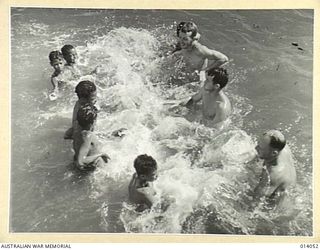 1943-01-11. ALLIED AIRMEN IN NEW GUINEA. NATIVE CHILDREN HAVING A SPLASHING GAME WITH, LEFT TO RIGHT - CPL. R. BOYLES OF TOLEDO, OHIO, AND PTE. 1ST CLASS E. LAUTZENHEISER OF DECATUR, INDIANA, AND ..