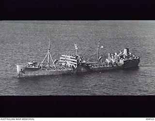 1944-07-19. AERIAL PORT BOW VIEW OF THE AMERICAN TANKER YORK WHICH RAMMED AND SANK THE CORVETTE HMAS GEELONG OFF LANGEMAK ON 1944-10-18. SHE IS ARMED WITH 3 INCH AA GUNS FORE AND AFT. FOUR 20 MM ..