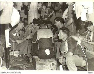 AT SEA. 1945-04-04. PERSONNEL OF 2/48 INFANTRY BATTALION PLAYING BRIDGE DURING AN AIR RAID ALERT ABOARD THE DUTCH TROOPSHIP MV VAN HEUTSZ WHILE THE VESSEL IS SAILING BETWEEN FINSCHHAFEN AND BIAK ON ..