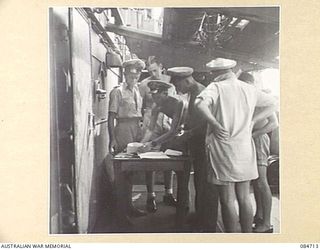 MIOS WUNDI, DUTCH NEW GUINEA. 1944-11-18. PERSONNEL RECEIVING THEIR PAY ABOARD HMAS BENDIGO