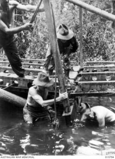 Bunga River, Lae, New Guinea. 1943-09. Erecting a pontoon bridge on the track to Lae to facilitate passage of artillery, which played a major part in the capture of Lae