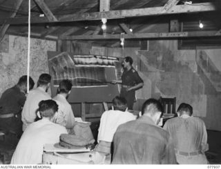 Torokina, Bougainville. 1944-12-30. VX337 Major W.M. Knox, GII (Intelligence), Headquarters, 2nd Australian Army Corps, briefing Allied service officers for a combined Naval - Air attack on ..