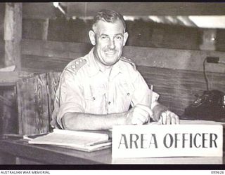 LAE, NEW GUINEA, 1946-01-11. CAPTAIN W. A. E. SPROTT, AREA OFFICER, WORKING IN HIS OFFICE AT AUSTRALIAN ARMY CANTEENS SERVICE BULK STORES