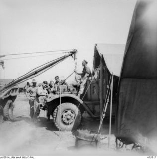 CAPE WOM, WEWAK AREA, NEW GUINEA. 1945-08-29. CRANE ON BREAKDOWN TRUCK BEING USED BY CORPORAL C. GUIGAN TO MOVE AN ENGINE AT 110 BRIGADE WORKSHOP, CORPS OF AUSTRALIAN ELECTRICAL AND MECHANICAL ..