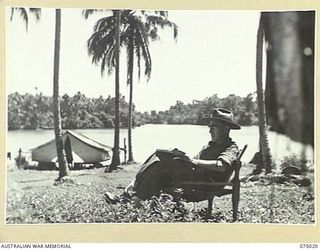 NAGADA, NEW GUINEA. 1944-08-02. WX3324 LIEUTENANT-COLONEL E.W. KYLE, COMMANDING OFFICER, 4TH FIELD AMBULANCE RELAXING IN THE SUN OUTSIDE HIS TENT