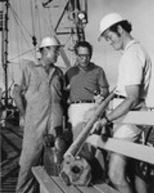 DEEP SEA BASALT-Cruise Co-Chief Scientists Drs. Tjeerd H. van Andel, center, and G. Ross Heath, right, both from Oregon State University, examine a section of late Cretaceous basalt recovered at Site 163 - 600 miles Southeast of Hawaii - on Leg Sixteeen of the Deep Sea Drilling Project. Cruise Operations Manager Dell Redding, of Phillips Petroleum Company, left, stands infront of a new three-cone "button bit" and a similar bit which was completely worn out after drilling through 164 feet of cherty sediments and 25 feet of basalt. Water depth at the site was 17,455 feet. Scripps Institution of Oceanography of the University of California at San Diego, is managing institution for the Deep Sea Drilling Project under contract to the National Science Foundation