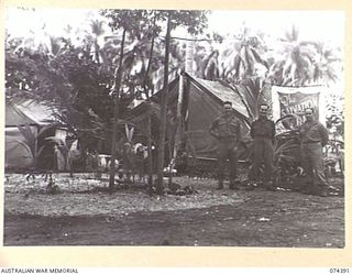 SIAR, NEW GUINEA. 1944-06-28. VX139884 CORPORAL A.A. JENKINS (1), VX89731 CORPORAL S.R. CHENERY (2) AND B3/99. MR. W.A. ALVIN, SALVATION ARMY (3) OUTSIDE THE SALVATION ARMY RED SHIELD TENT AT ..