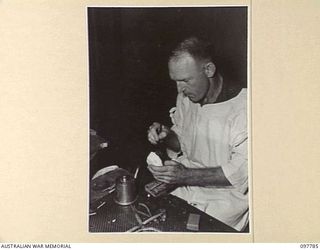 RABAUL, NEW BRITAIN, 1945-10-08. STAFF SERGEANT C.H. FERRIS, DENTAL SECTION, 105 CASUALTY CLEARING STATION, SETTING UP A SET OF TEETH