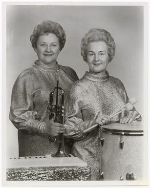 Lucy Rhinehart with a trumpet and Helen Montgomery with a drum.