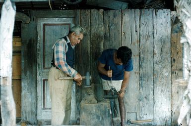 Teraia Cough Marsters and his "labour", Kainga, "knocking" fish spears in the Carpenter House, Palmerston Islet.