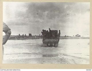 BABIANG AREA, NEW GUINEA, 1944-11-18. A 3 TON GMC TRUCK LOADED WITH 2/11 INFANTRY BATTALION TROOPS FOLLOWING JEEPS OF THE 2/10 COMMANDO SQUADRON, EASILY CROSSES THE DRINIUMOR RIVER