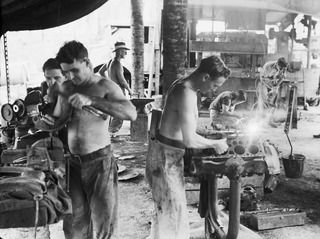 MADANG, NEW GUINEA. 1944-08-15. TROOPS OF HEADQUARTERS SECTION, 165TH GENERAL TRANSPORT COMPANY BUSILY ENGAGED ON THEIR VARIOUS JOBS OF REPAIR AND MAINTENANCE. IDENTIFIED PERSONNEL ARE:- NX128939 ..