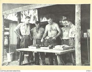 MILILAT, NEW GUINEA. 1944-08-01. COOKS OF HEADQUARTERS, 5TH DIVISION CUTING UP THE BI- WEEKLY SUPPLY OF FRESH MEAT. IDENTIFIED PERSONNEL ARE:- QX50765 PRIVATE L. MITCHELL (1); QX50774 PRIVATE C.W. ..