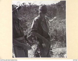 MOUNT SHIBURANGU, WEWAK AREA, NEW GUINEA. 1945-09-21. LIEUTENANT K.F.D. DOWE, HEADQUARTERS 6 DIVISION AT A CONTROLLING POINT AT MAKOW ON THE TOP OF MOUNT SHIBURANGU. AT THIS POINT JAPANESE SOLDIERS ..