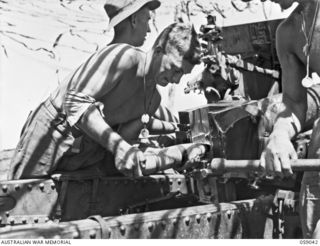 RAMU VALLEY, NEW GUINEA. 1943-10-23. VX123662 GUNNER (GNR) E. DEACON (1) AND VX47511 GNR E. A. GRAY (2) OF "F" TROOP, 54TH BATTERY, 2/4TH AUSTRALIAN FIELD REGIMENT LOADING A 25-POUNDER GUN. NOTE ..