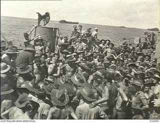 AT SEA NEAR AITAPE, NORTH EAST NEW GUINEA. 1944-04-21. PREPARED FOR ACTION, WEARING HATS, PERSONNEL OF MOBILE WORKS UNITS, DESIGN AND SURVEY UNITS, AND SIGNALS UNITS, RAAF, GATHER ON THE DECK OF A ..
