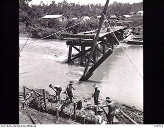 DONADABU, NEW GUINEA. 1943-11-03. SAPPERS OF THE 24TH AUSTRALIAN FIELD COMPANY, ROYAL AUSTRALIAN ENGINEERS, CONSTRUCTING A NEW EIGHT SPAN WOODEN BRIDGE OVER THE LALOKI RIVER. AT THIS STAGE THE ..