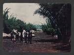 Group of people talking, buildings in background, upper Ramu River, Asai Valley, Papua New Guinea, 1950