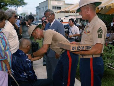 Governor Ricardo J. Bordallo of Guam watches as Colonel J. Karl Miller, with Sergeant Major Ables assisting, presents the Asiatic-Pacific Campaign Medal and the World War II Victory Medal to Vincente Borja. Borja is one of 34 recipients of the medals being presented during a Veterans Day memorial service held at Skinner Plaza