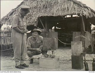 MADANG, NEW GUINEA. 1945-03-27. RAAF SERVICE POLICE AT WORK IN NEW GUINEA ARE 75209 PILOT OFFICER (PO) J. N. DONNELLY OF BRISBANE, QLD, AND 130705 WARRANT OFFICER (WO) C. A. PEARCE OF SYDNEY, NSW, ..