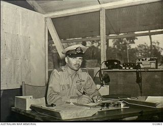 TOROKINA, BOUGAINVILLE ISLAND, SOLOMON ISLANDS. 1945-08-27. GROUP CAPTAIN (GP CAPT) DIXIE ROBISON CHAPMAN OF ADELAIDE, SA, IN COMMAND OF THE RAAF UNITS, SEATED AT HIS DESK IN HIS JUNGLE ..