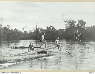 MILILAT, NEW GUINEA. 1944-10. A DETACHMENT FROM HQ 4 ARMOURED BRIGADE USING A DIVING BOARD CONSTRUCTED FROM COCONUT LOGS