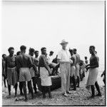 Father Laughman, men, boys, and canoe on shore