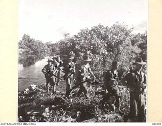 AWAR POINT, NEW GUINEA. 1944-07-09. A PATROL FROM NO. 14 PLATOON, C COMPANY, 30TH INFANTRY BATTALION, LED BY CORPORAL STEWART (3), MOVES ALONG A STREAM NORTH OF AWAR. IDENTIFIED PERSONNEL ARE:- ..