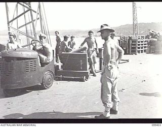 WEWAK HARBOUR, NEW GUINEA, 1945-12-13. APPROXIMATELY 2,200 MEMBERS OF 6 DIVISION EMBARKED ON THE AIRCRAFT CARRIER HMS IMPLACABLE FOR RETURN TO AUSTRALIA. SHOWN, THE UNIT STORES BEING LOADED ABOARD ..