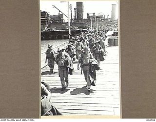 PORT MORESBY, PAPUA. 1942-09. TROOPS OF THE 25TH AUSTRALIAN INFANTRY BRIGADE DISEMBARKING FROM TROOPSHIPS AT THE WHARF AT PORT MORESBY