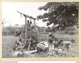 RABAUL, NEW BRITAIN. 1945-09-14. TROOPS OF D COMPANY, 37/52 INFANTRY BATTALION, WHO ARE OCCUPYING THE AREA FOLLOWING THE SURRENDER OF THE JAPANESE, WASHING AT A WELL IN THE TOWNSHIP. WATER IS ..