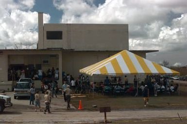 Typhoon victims are bussed in from schools used as shelters to temporary housing in converted dorms at Andersen Air Force Base south, Guam, after Super Typhoon Paka destroyed or badly damaged their homes. Here they may have a bit more privacy and better facilities as well as freeing up schools to begin classes in January