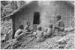 Boys around fire in front of the men's house